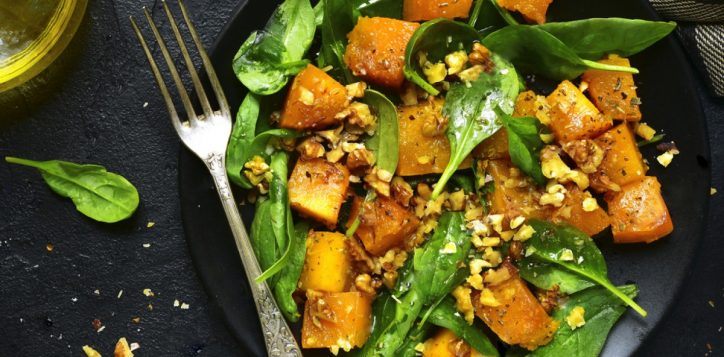 stock-photo-roasted-pumpkin-salad-with-spinach-and-walnut-on-a-black-plate-on-a-stone-background-top-view-496234729-2