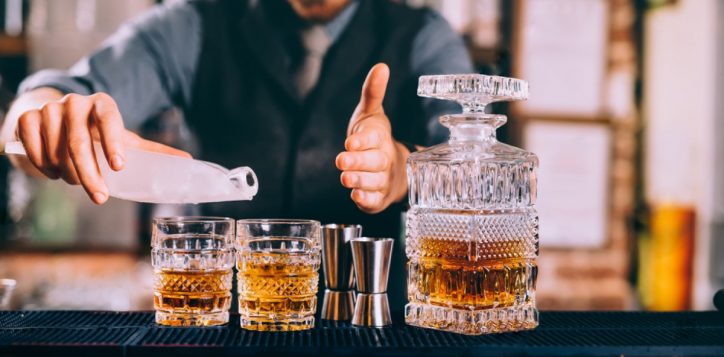stock-photo-close-up-of-barman-hands-adding-ice-and-whiskey-to-modern-urban-cocktails-sky-bar-serving-elegant-764280106-2
